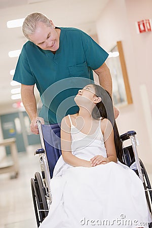 An Orderly Pushing A Little Girl In A Wheelchair Stock Photo