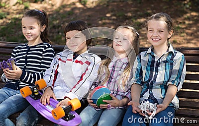 Ordinary children in the park on a bench in autumn Stock Photo