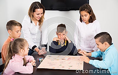 Ordinary children sitting at table with board game Stock Photo