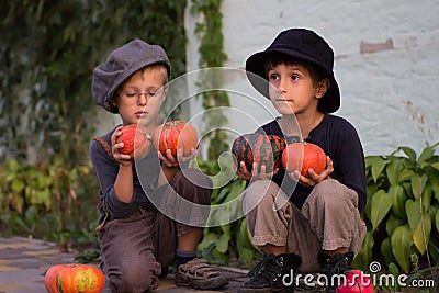 Ordinary kids sitting with Halloween pumpkins Stock Photo