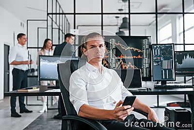 Ordinary office day. Team of stockbrokers works in indoors with many display screens Stock Photo