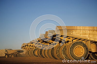 Ore hauling trucks in row Telfer Western Australia Stock Photo