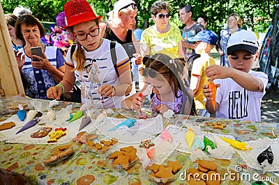 Orel, Russia - August 04, 2018: Samovar fest. Children paint homemade cookies with food coloring Editorial Stock Photo