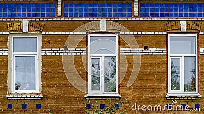 Modern plastic double-glazed windows in the windows of an old brick building, a fragment of the facade Editorial Stock Photo