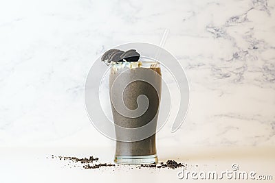 Chocolate Cookies Milkshake with Straw in Tall Transparent Glass with Cookie Crumbs Stock Photo