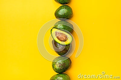 Organic avocados half cut with seed and whole fruit on yellow table background.Healthy super foods for diet.Fresh vegetable from Stock Photo