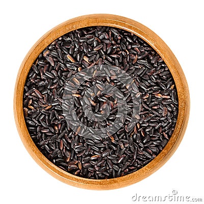 Organic black rice in wooden bowl over white Stock Photo