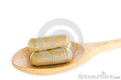 Organic capsule. Herb medical in wooden spoon. Stock Photo