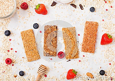 Organic cereal granola bar with berries with honey spoon and jar of oats on marble background. Top view. Strawberry, raspberry and Stock Photo