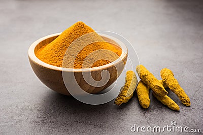 Organic Haldi or Turmeric powder spice pile in a bowl with whole, selective focus Stock Photo