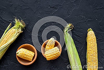 Organic farm food. Cutted corn cobs on black stone background top view copyspace Stock Photo