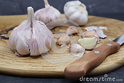 Organic garlic. Fresh garlic cloves and garlic bulb on a wooden cutting board Stock Photo