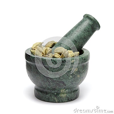 Organic Green cardamom (Elettaria cardamomum) on marble pestle. Stock Photo