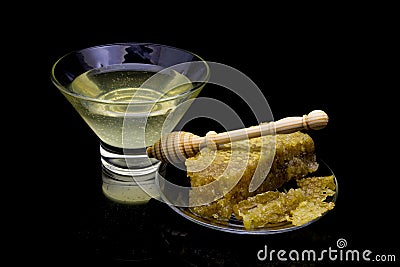 Organic honeycomb with honey isolated on black background with reflection. close up of natural honeycomb and honey spoon. Honey dr Stock Photo