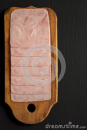 Organic Jamon Cocido Extra on a rustic wooden board on a black background, top view. Flat lay, overhead, from above. Copy space Stock Photo