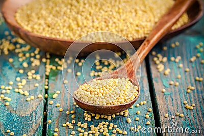 Organic millet seeds in a wooden spoon closeup Stock Photo