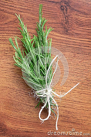 Organic natural fresh rosemary tied with a thread on a wooden table Stock Photo