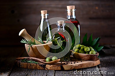 Organic olive oil with spices and herbs on an old wooden background. Healthy food. Stock Photo