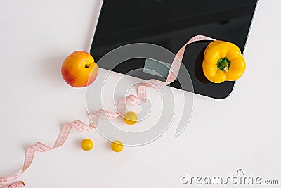 Organic peach and pepper and measuring tape for weighing scales with a diet of vegan vegetables. Diet and healthy lifestyle. Slim Stock Photo