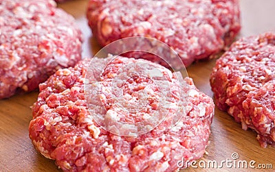 Organic raw ground beef, round patties for making homemade burger on wooden cutting board Stock Photo