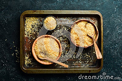 Organic rice groats in a wooden bowl. on a stone background. Stock Photo