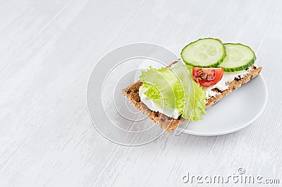Organic season sandwiches on dry brown grain crispbread with fresh sliced vegetables - green salad, cucumber, tomato, cream cheese Stock Photo