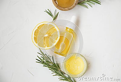 Organic skincare ingredients top view, lemon and rosemary oil bottle and herb, manuka honey and balm salve Stock Photo
