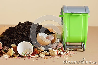 Organic waste, heap of biodegradable food compost with decomposed organic matter on top and green bin near Stock Photo
