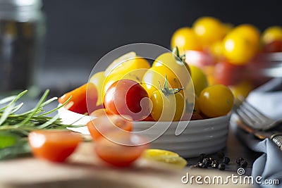 Yellow and red tomatoes in plate, isolated over dark background Stock Photo