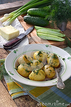 Organically grown new potatoes with butter and dill on wooden background. First spring harvest Stock Photo