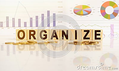 ORGANIZE the word on wooden cubes, cubes stand on a reflective surface, in the background is a business diagram Stock Photo