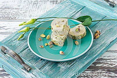 Orient pistaschio sliced halva. sweet dessert on a plate with flowers Stock Photo