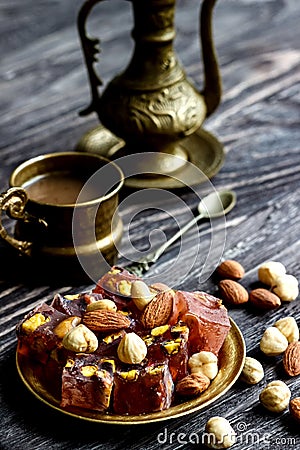 Oriental Arabian sweets with different nuts a cup of coffee. Eastern sweets. Traditional Turkish delight Rahat lokum on a wooden Stock Photo