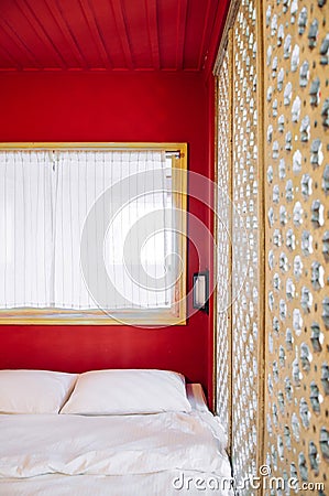 Oriental vintage bedroom in old house with red wall and carved wood partition Editorial Stock Photo