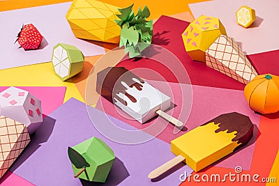 Origami ice cream and handmade cardboard fruits on multicolored paper. Stock Photo