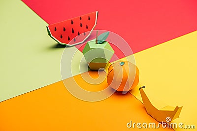 Origami watermelon, apple, tangerine and banana on colorful paper. Stock Photo