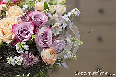 Original bouquet with roses, ranunculuses in a skeleton from branches Stock Photo