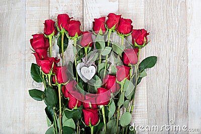 Original festive arrangement of long red roses - El Toro variety in the shape of a heart with wooden hearts in the center on a Stock Photo