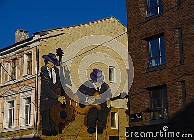 Original graphic design on the wall of an old brick house. Drawing of two musicians playing on the wall. Editorial Stock Photo