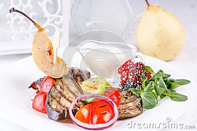 Original meat dish with vegetables and pear. Stock Photo