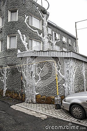 Original stylish and creative decoration wall of a modern building and fence in the form of old trunks, imitation wood, painted w Stock Photo