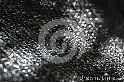The original texture of the woven network or black nylon net with bokeh and sunlight spots Stock Photo