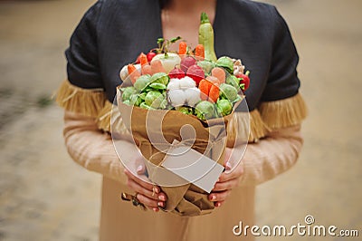 The original unusual edible vegetable and fruit bouquet with card in woman hands Stock Photo