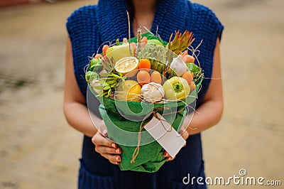 The original unusual edible vegetable and fruit bouquet with card in woman hands Stock Photo