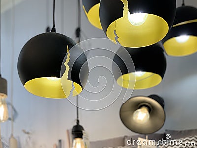 Original yellow-black ceiling lights. Modern chandeliers in the electrical goods store. Pendant floor lamps for interior Stock Photo