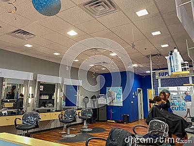 A hairdresser cutting a womens hair at a Supercuts hair salon Editorial Stock Photo