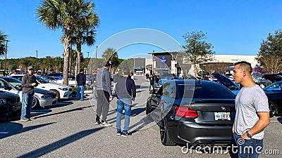 People browsing at automobiles at a free to the public Cars and Coffee car show Editorial Stock Photo