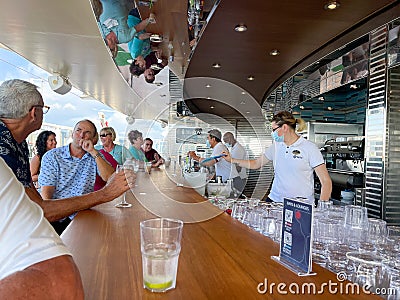 Bartenders serving drinks at an outdoor bar on the MSC Cruise Ship Divina Editorial Stock Photo