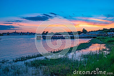 Beautiful panoramic view of Grand Floridian Resort & Spa, green forest and Magic Kingdom wharf on colorful sunset background at Wa Editorial Stock Photo