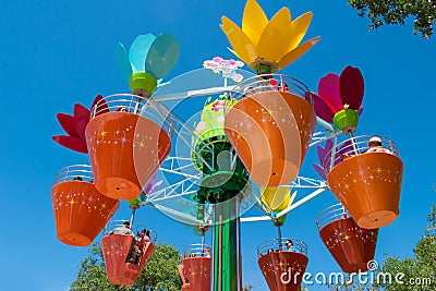 .Parents and kids enjoying colorful flower pots aboard Abbyâ€™s Flower Tower on lightblue sky background at Seaworld in Internati Editorial Stock Photo